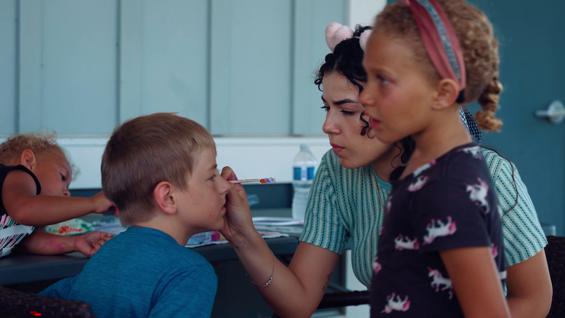 Child getting their face painted in the Kids Zone
